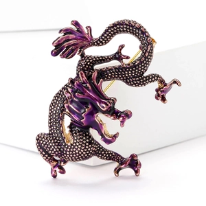 Detail shot of vintage purple enamel dragon brooch with intricate golden plating scales