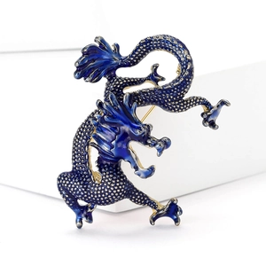Detailed view of dark blue enamel dragon brooch with golden scales on white stone