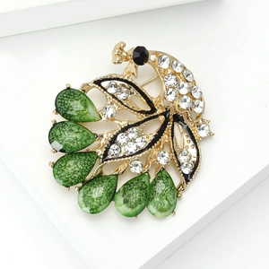 Elegant gold peacock brooch with green teardrop gems and sparkling white rhinestones