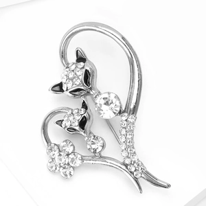 Close-up of heart-shaped fox brooch with white crystals and floral details