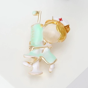 Close-up of a cartoon nurse brooch with a green syringe and opal stone head detail