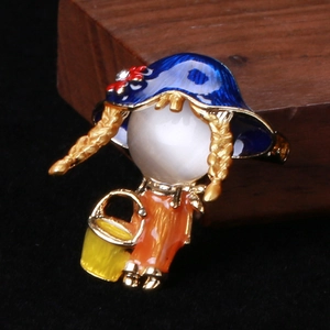 Détail d'une broche fillette avec pierre oeil de chat blanche et émail bleu coloré