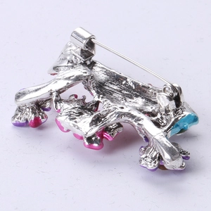 Detail view of bird brooch back with secure silver metal safety pin and enamel art