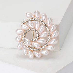 Detalle de broche floral en espiral con perlas y diamantes en una base geométrica