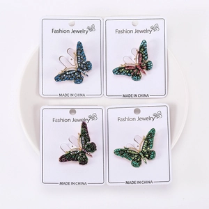 Detail view of four butterfly brooches with colorful rhinestones on display cards