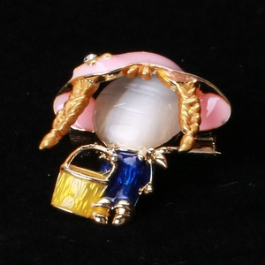 Détail de la broche petite fille avec chapeau rose, visage en opale et robe émaillée