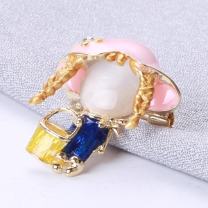 Détail de la broche petite fille avec chapeau rose, tresses dorées et pierre opale fine