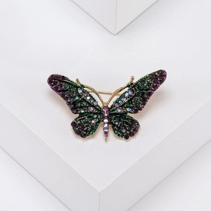 Detailed view of butterfly brooch with colorful rhinestones on a geometric stand