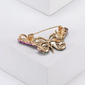 Detailed back view of a butterfly brooch showing the gold base and pin fastening mechanism
