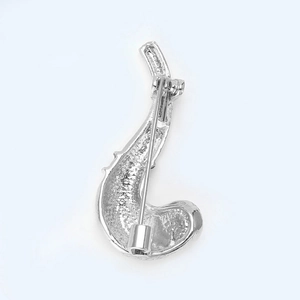 Detail of silver metal pipe brooch back with textured surface and safety pin clasp