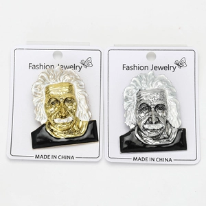 Detail view of gold and silver Einstein portrait brooches with high-quality alloy relief