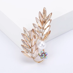 Élégante broche feuille dorée avec cristaux champagne et perle blanche sur support