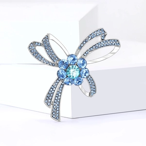 Broche nœud élégante en argent avec strass bleus et fleur en cristal scintillant