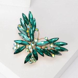 Detailed macro shot of the green emerald crystal butterfly brooch with golden plating
