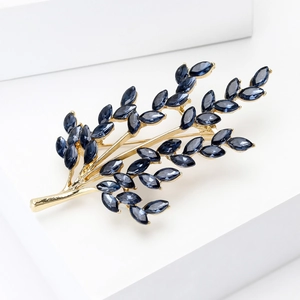 Detailed macro view of golden tree brooch with elegant marquise-cut blue rhinestones