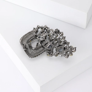 Detail view of the vintage gunmetal safety pin brooch showing the back closure and rhinestones