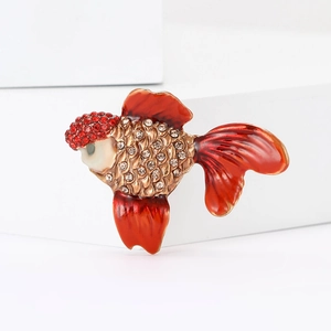 Elegant goldfish brooch with red enamel and sparkling rhinestones on white display
