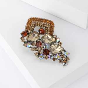 Detail of vintage bronze brooch with amber water-drop rhinestones and crystal inlay