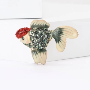 Detailed macro view of goldfish brooch featuring red and black rhinestones with enamel fins