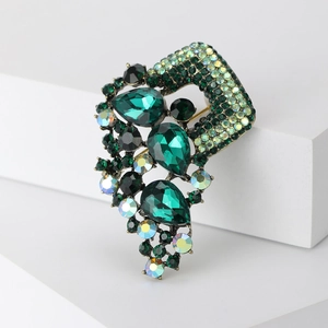 Detail view of large vintage green crystal brooch with pear-shaped stones and AB finish