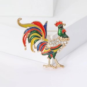 Dettaglio macro di spilla a gallo in smalto dipinto a mano con cristalli su metallo dorato