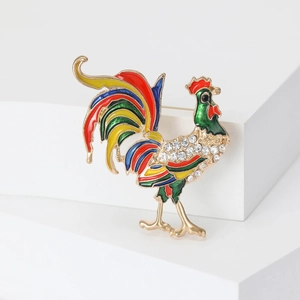 Squisita spilla a forma di gallo colorato con strass scintillanti su pedana bianca minimale