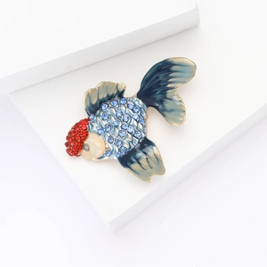 Detailed view of fish brooch featuring blue rhinestones and gradient enamel fins