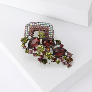 Detail view of a vintage alloy brooch with colorful crystals on a bronze metal base