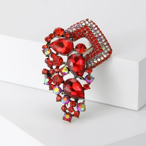 Detail of vintage red teardrop crystal brooch with AB rhinestone inlay on dark alloy