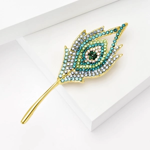 Dettaglio della spilla vintage a piuma di pavone con strass multicolori scintillanti