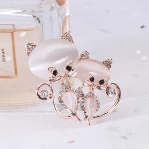 Détail d'une broche chat en or rose avec pierres oeil-de-chat roses et cristaux
