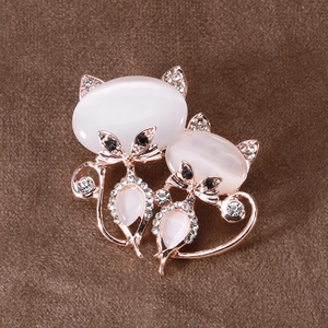 Détail de la broche double chat en or rose avec pierres oeil de chat et cristaux