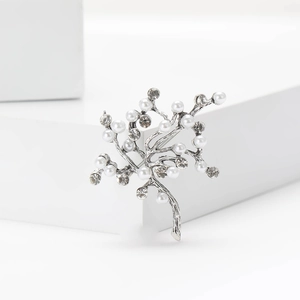 Détail macro d'une broche arbre en argent élégante avec perles et strass brillants