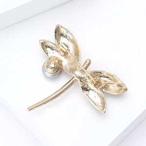 Golden dragonfly brooch with pearl detail and textured back view on white stand