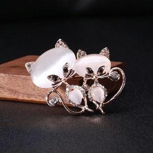 Détail de la broche chat en or rose avec pierres oeil-de-chat en opale et cristaux brillants