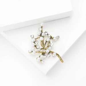 Détail de la broche arbre à perles avec branches dorées et strass brillants de luxe