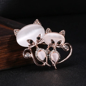 Détail de la broche chat or rose avec pierres d'opale blanche et cristaux scintillants