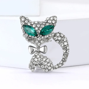 Détail de la broche chat argentée avec strass blancs et yeux vert émeraude