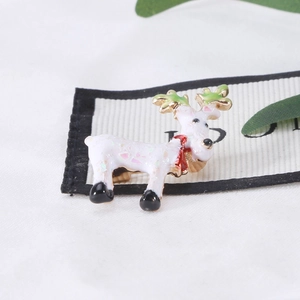Cute reindeer Christmas brooch with white enamel and glitter on textured background