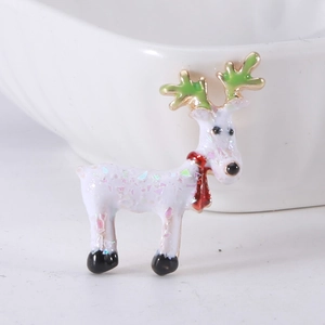 Close-up of a white reindeer brooch with colorful sequins and a festive red scarf