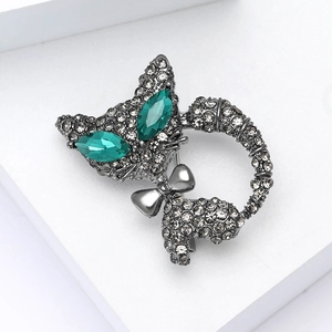Broche chat élégante en argent avec yeux émeraude et cristaux gris étincelants