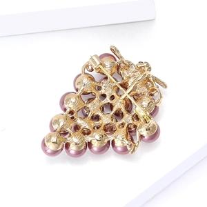 Élégante broche grappe aux perles roses montrant l'épingle arrière et la structure