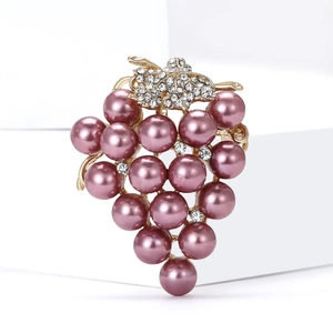Détail d'une broche raisin avec perles mauves et feuilles dorées ornées de strass brillants