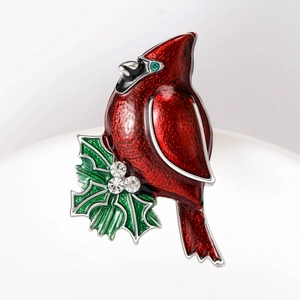 Red cardinal enamel brooch with holly leaves and crystal details on white display