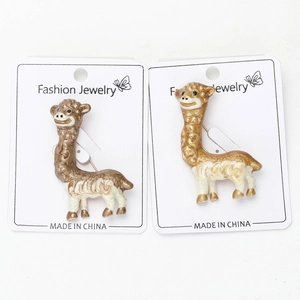 Dettaglio di spille ad alpaca in smalto marrone e oro su cartoncino per gioielli moda