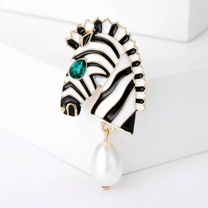 Broche zèbre dorée chic avec rayures en émail noir et une perle blanche en forme de goutte