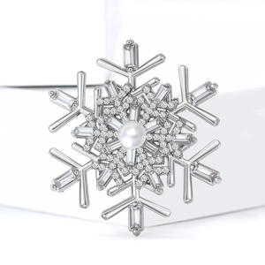 Detailed macro view of silver snowflake brooch with central pearl and sparkling zircon stones