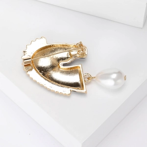 Broche tête de cheval dorée en forme de G avec rayures et perle goutte blanche