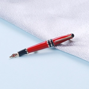 Detailaufnahme einer Vintage-Füllfederhalter-Brosche mit roter und schwarzer Emaille