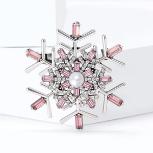 Elegant silver snowflake brooch with pink crystals and a white pearl on a display stand